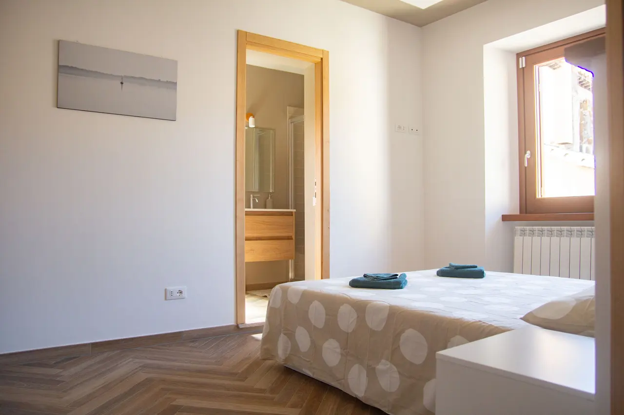 Camera luminosa con letto matrimoniale e bagno adiacente, per maggiore comfort e praticità.